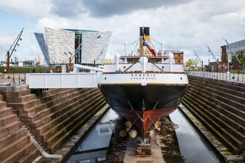 The Titanic ship docked in Belfast, showcasing its grandeur, with Wee Toast Tours logo in the corner.