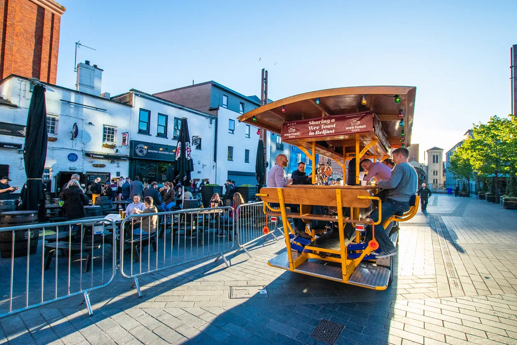 A trolley filled with people rides through a bustling city, showcasing the Wee Toast Tours experience.